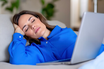 A tired young businesswoman in blue resting at home during remote work hours, worn out by Blue Monday.