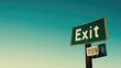 © Artyom - Green exit sign with clear blue sky in background