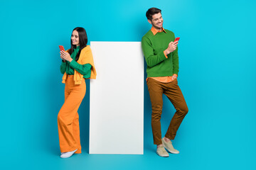 Poster - Full size photo of two bloggers advertise new technology search menu smartphone isolated on blue color background