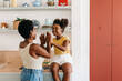 © (JLco) Julia Amaral - Happy little girl playing a hand clapping game with her mother at home