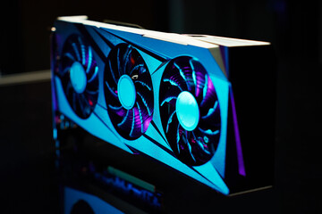 Fototapete - Close-up of high-performance graphics card with three cooling fans with neon lighting. Modern video card for gaming and advanced computing