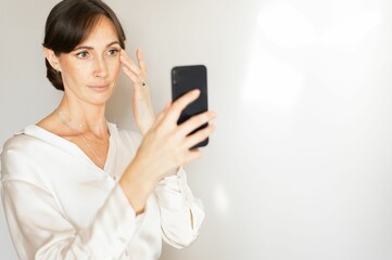 Middle-aged woman taking a selfie with smartphone.