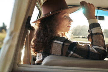 Woman Looking Out of Camper Van Window at Sunset