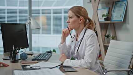 Wall Mural - Gynecologist listening pregnant woman in medical office. Closeup doctor writing