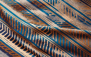 Abstract blue gold fabric. Closeup of a textured fabric with blue and gold striped patterns. This abstract design evokes a sense of movement and energy.