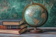 © YouraPechkin - Vintage globe beside stacked books on a rustic table with a green backdrop