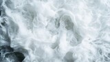 An abstract capture of dynamic white foamy waves, showcasing the natural power and fluidity of water as it creates ever-changing shapes and textures.