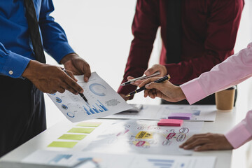 Businessman meeting with colleagues are discussing business situation analysis by charts in financial reports and making plans to increase company profits.