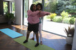 © Caia Image - Woman supports her disabled friend while practicing yoga
