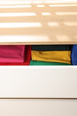 Poster - Chest of drawers with different folded clothes, closeup