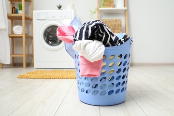 Sticker - Plastic basket full of laundry on floor in bathroom