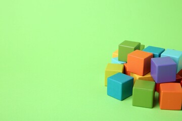 Sticker - Many wooden colorful cubes on green background, space for text