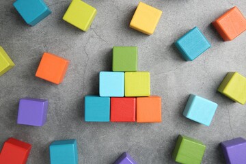 Canvas Print - Many wooden colorful cubes on gray textured background, top view