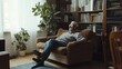 © Johannes - senior man happiness sitting on the sofa and listening music with headphone at living room for relaxing