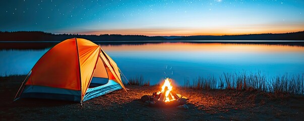 Wall Mural - orange tent beside a calm lake at sunset with a cozy campfire.
