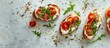 © Ilgun - Scrumptious ricotta tomato and arugula bruschettas on a lightly textured table in a flat lay composition with copy space image available
