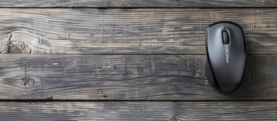 Poster - top view of a wireless mouse on a grey wooden table with ample space for text in the copy space imag