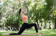 © wichayada - Young Healthy Woman Practicing Yoga Outdoors in a Lush Green Garden on a Sunny Day