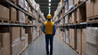 ©  Visual Pioneer - worker in yellow vest and hard hat stands in large warehouse, surrounded by tall shelves filled with boxes. scene conveys sense of organization and industry