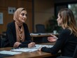 © Alex Pios - Serious young Arab manager woman in hijab talking to female business colleague in office meeting room space with large table, explaining teamwork, project management, speaking, moving hand
