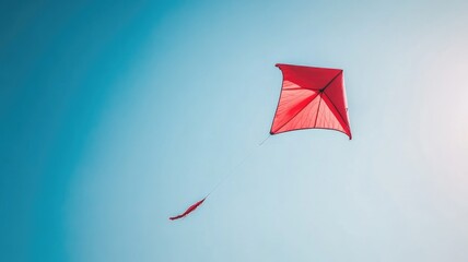 vibrant red kite soaring in clear blue sky during daytime