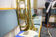 © andov - A trumpet, a brass musical instrument, lies on a bench next to sheet music in an orchestra.