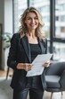 © spyrakot - Confident Businesswoman in Modern Office Holding Successful Report for Professional Achievement