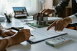 ©  NCST Studio - Client is signing a contract to purchase a new home with their real estate agent pointing at the signature line