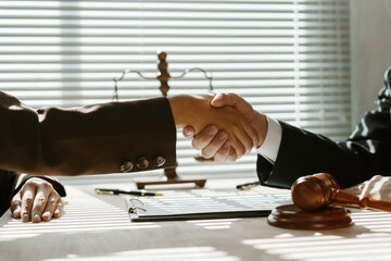 Wall Mural - Lawyer and client shaking hands after reaching an agreement in the office, legal and advice concept