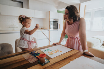 Mother and daughter enjoying a fun painting session at home in a cozy kitchen setting. Art and creativity bonding time.