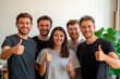 © Olga - Group of five friends smiling and giving thumbs up, showing positivity and team spirit