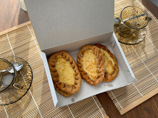 There are three pieces of bread topped with cheese placed in a box on the table