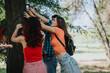 © qunica.com - Group of friends assembling a hammock between the trees in a park on a bright day. Enjoying outdoor activities and teamwork.
