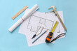 © Pixel-Shot - Architect's supplies with house plans on blue background