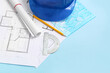 © Pixel-Shot - Architect's supplies with house plans on blue background, closeup