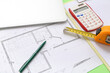 © Pixel-Shot - Architect's supplies with house plan and laptop on green background, closeup
