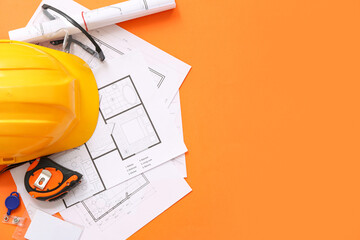 Wall Mural - Architect's supplies with hardhat and house plans on orange background