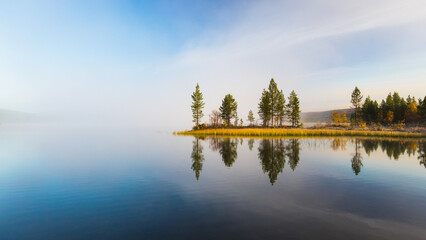 quiet, calm and peaceful autumn frozen morning at the finnish lake with breathtaking view to trees o