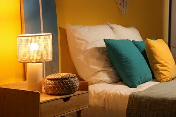 Canvas Print - Bed and bedside tables with glowing lamp in interior of bedroom