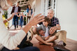 © Marko Geber - Grandparents and grandchildren playing with soccer ball on house porch