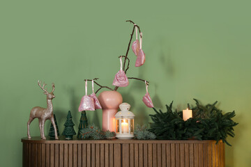 Advent calendar with Christmas decor on drawers near green wall