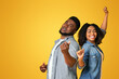 © Prostock-studio - Positive african american couple having fun together,singing and dancing over yellow background in studio, copy space