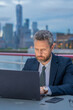 © Volodymyr - Businessmen trading online. Outdoor portrait of handsome business man with a laptop. Successful USA businessman. Man using laptop outdoor in New York City. Business success. American business dream.