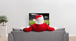 © Ljupco Smokovski - Santa claus on a sofa in a living room watching a football match
