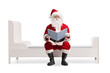 © Ljupco Smokovski - Santa Claus reading a book and sitting on a bed