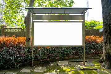 Wall Mural - Background texture of a blank, white rectangular billboard mockup stands with a protective canopy overhead and is mounted on a metal stand in a park.Showcasing advertising or informational content 