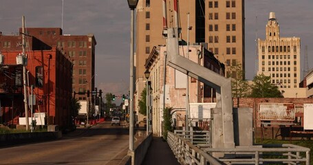 Wall Mural - Afternoon traffic passes on a bridge into historic downtown Monroe, Louisiana, USA.