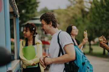 Poster - A group of multicultural students relaxes in a park, enjoying ice cream and leisure time between classes. The picture captures friendship and diversity in a natural outdoor setting.