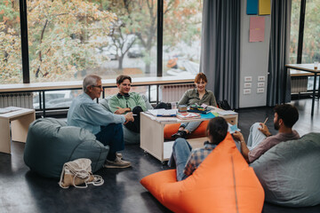 A professor engages with students in an informal classroom environment, fostering open dialogue and collaborative learning while sitting on bean bags. The scene highlights an interactive and modern