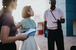 © qunica.com - Group of diverse business professionals engaging in a meeting outdoors in the city, exchanging ideas and fostering collaboration. The image captures teamwork, diversity, and modern urban business